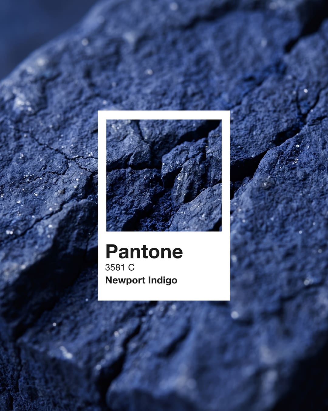 Uma amostra Pantone 3581 C Newport Indigo sobre uma pedra azul-escura rugosa.
