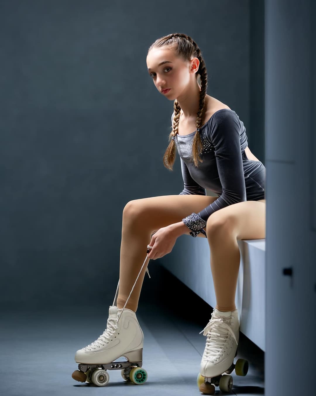 Madalena Costa sentada num banco a apertar os patins.
