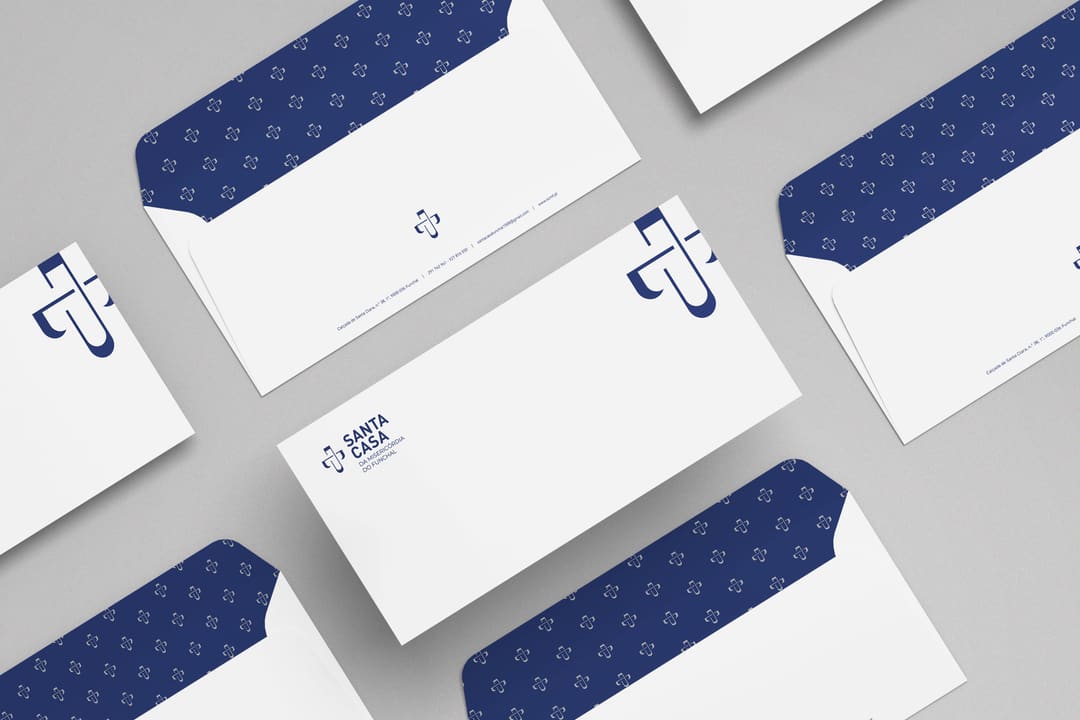 Envelopes DL brancos com o logótipo e a aba azul com o padrão do símbolo.