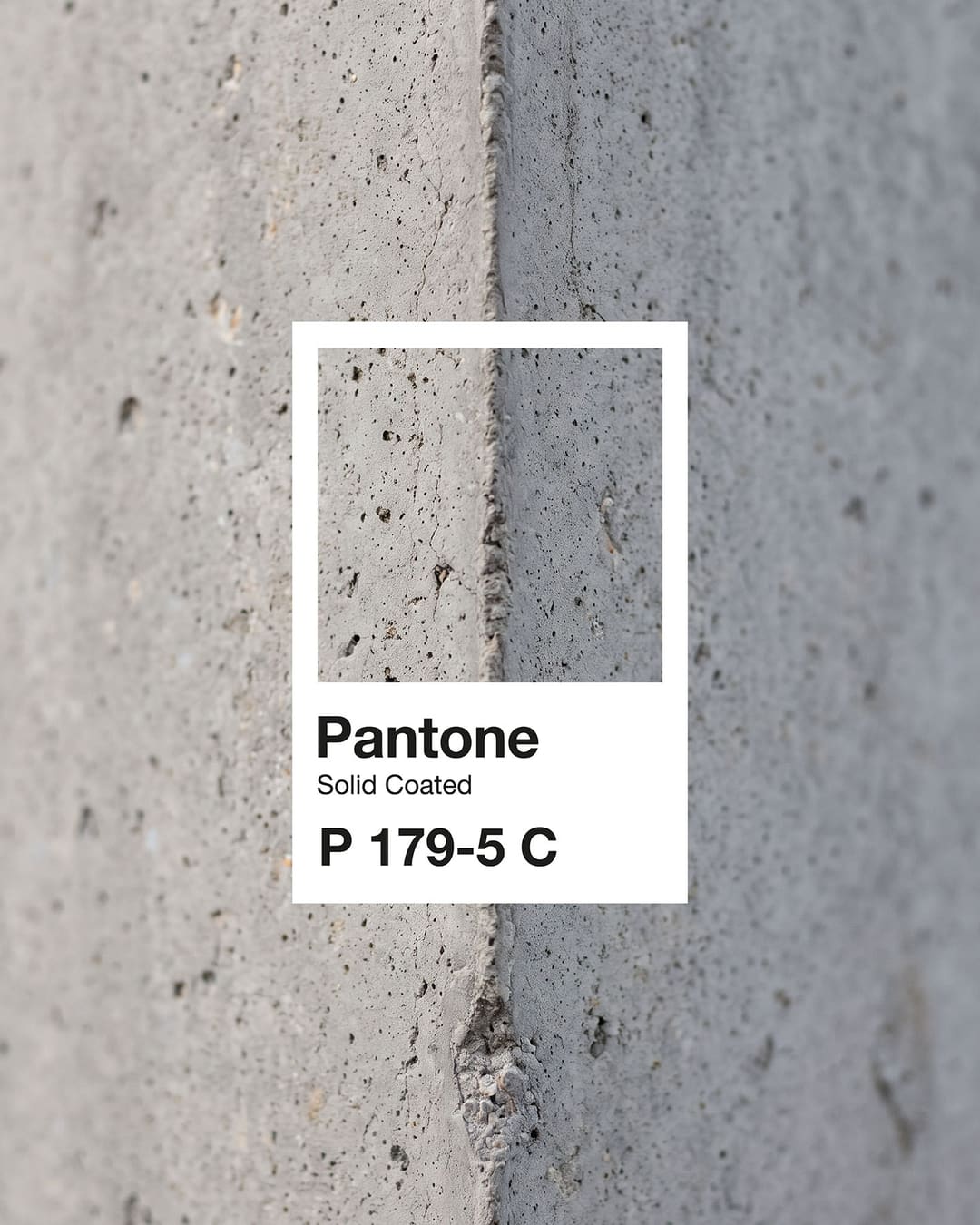Uma amostra Pantone P 179-5 C sobre uma esquina de betão cinzento.